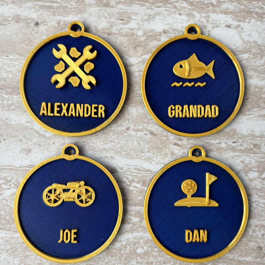 Four navy and gold personalised hobby ornaments: mechanic, fishing, golf and motorbike, each with a name